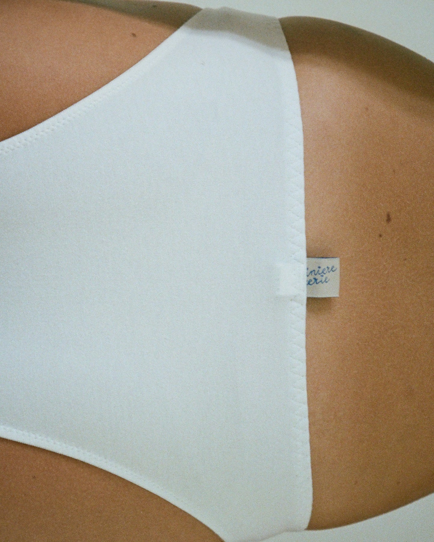 White cotton panties with broderie anglaise on model.